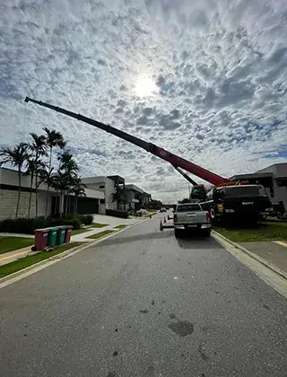 Guindaste em ação na rua, céu nublado.